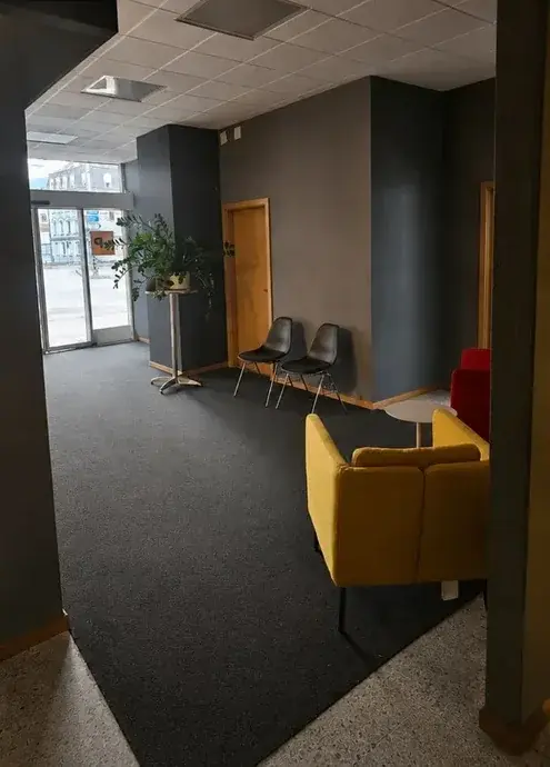 Espace d’accueil de bureaux avec fauteuil jaune et sol dégagé, après nettoyage CCB